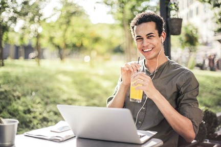 A young man smiling with a glass of orange juice