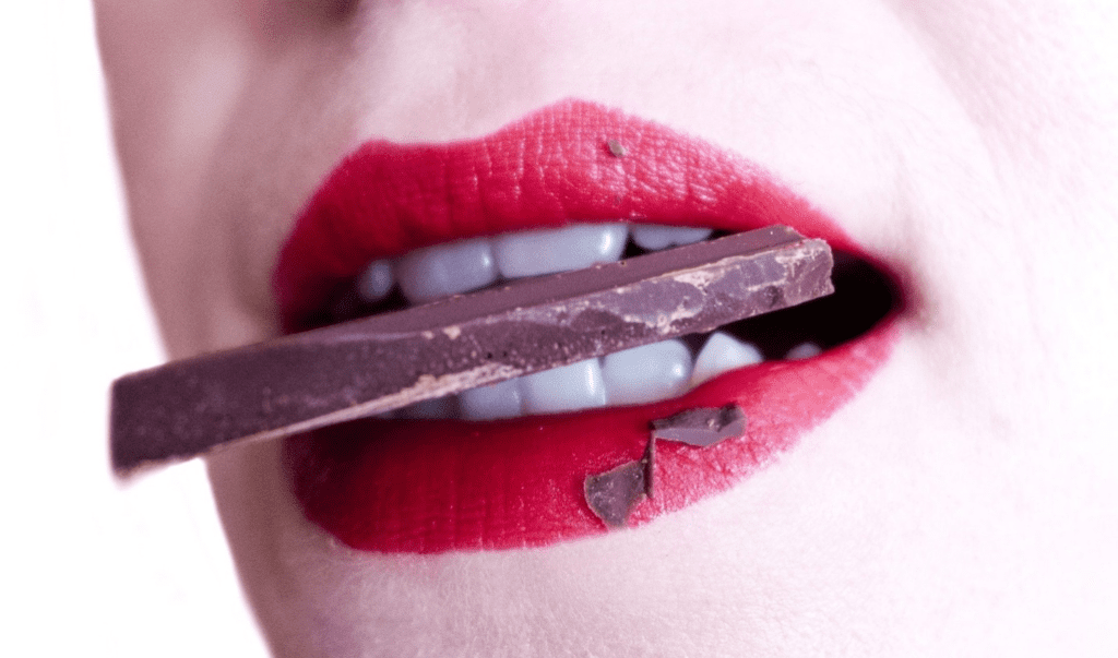 A woman biting chocolate