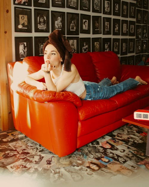 a woman lying on a red couch