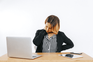 a woman experiencing neck pain while at work
